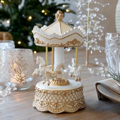 Chic Antique nostalgisk speldosa Noël i antik creme och guld med karusellhästar på ett dukat julbord.