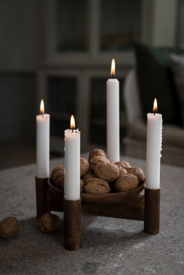 Adventsljusstake i mörkt trä på ett bord med duk och fyra tända ljus från Ernst.